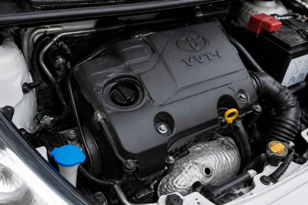Silnik Toyoty VVT-i pod maską samochodu z widocznym korkiem oleju i bagnetem poziomu oleju