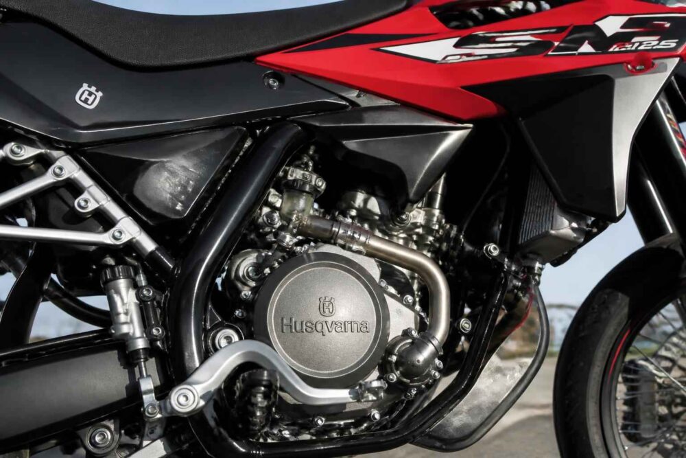 Zbliżenie na silnik i ramę czerwono-czarnego motocykla Husqvarna definiującego techniczny charakter pojazdu